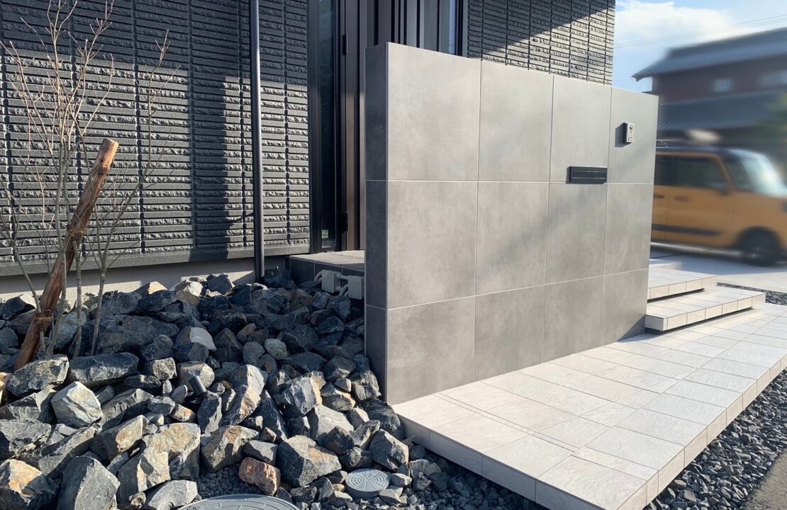 玄関ドアをやわらかく隠す高さのある造作門柱とフロート階段の新築外構