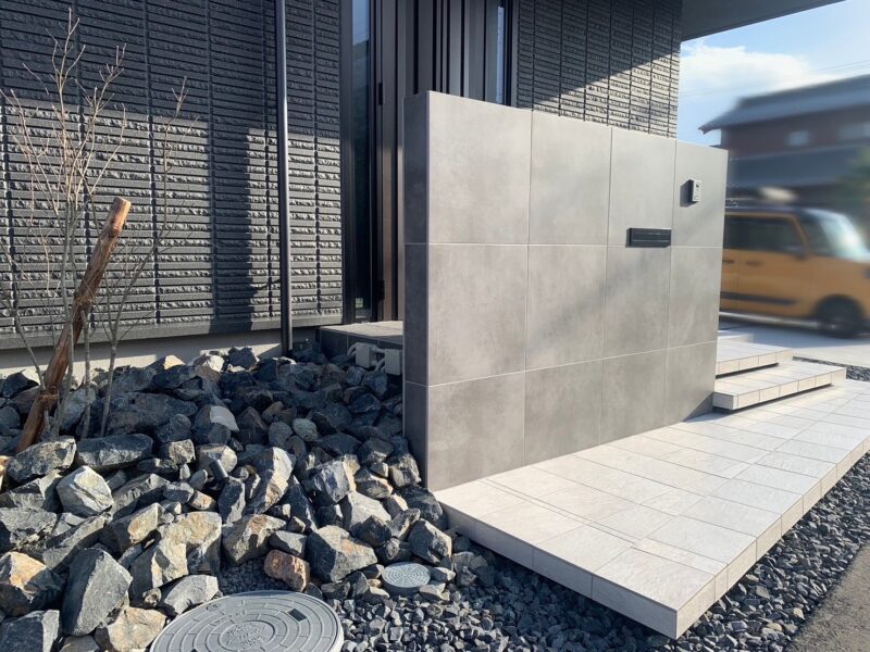 玄関ドアをやわらかく隠す高さのある造作門柱とフロート階段の新築外構